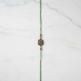 Vanasri Green Meenakari Rakhi on marble - Divine Sansar UAE