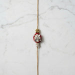 Velvet rose mirror and pearl rakhi on marble - Divine Sansar